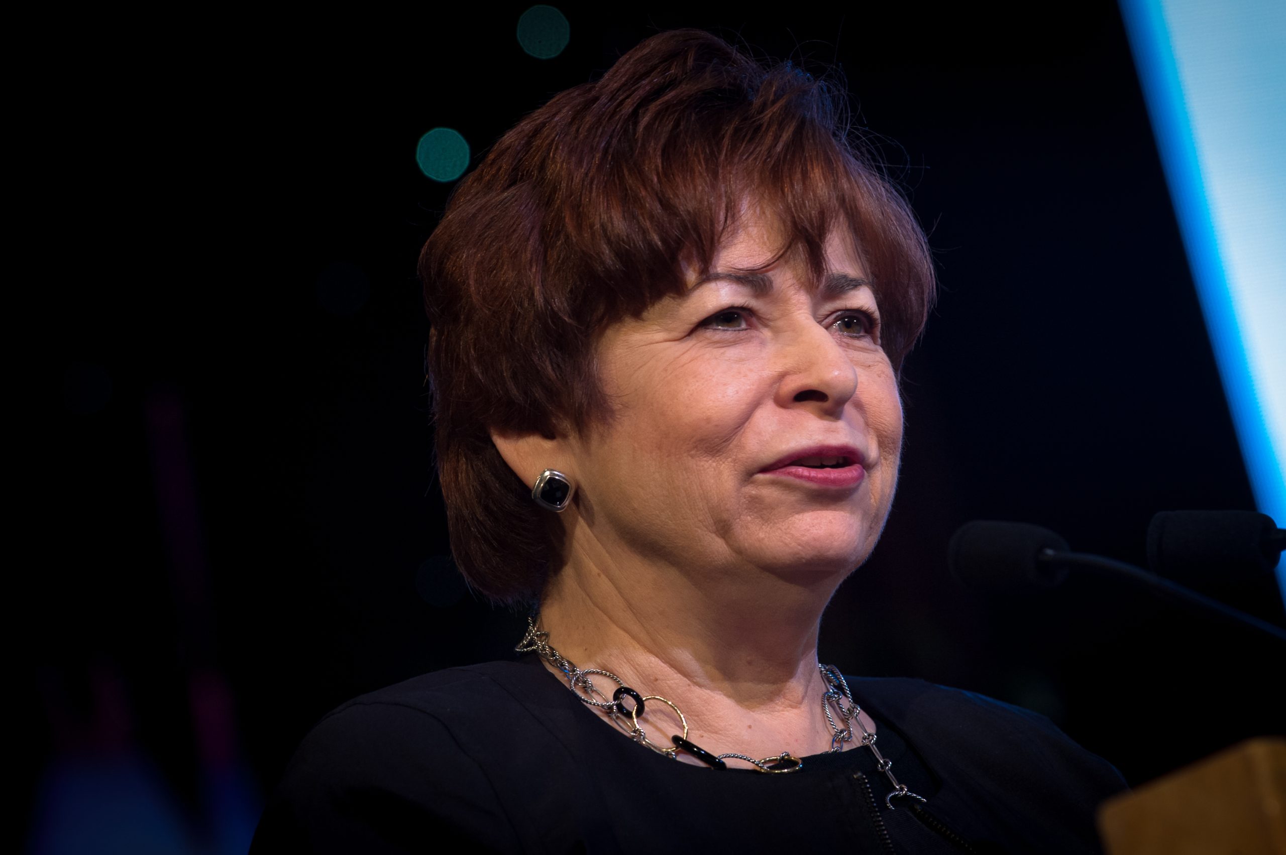 Slight profile of woman with short read hair speaking