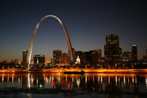 St. Louis on the Mississippi river by night/ Jefferson National Expansion Memorial aka. Gateway Arch and Old Courthouse are visible.